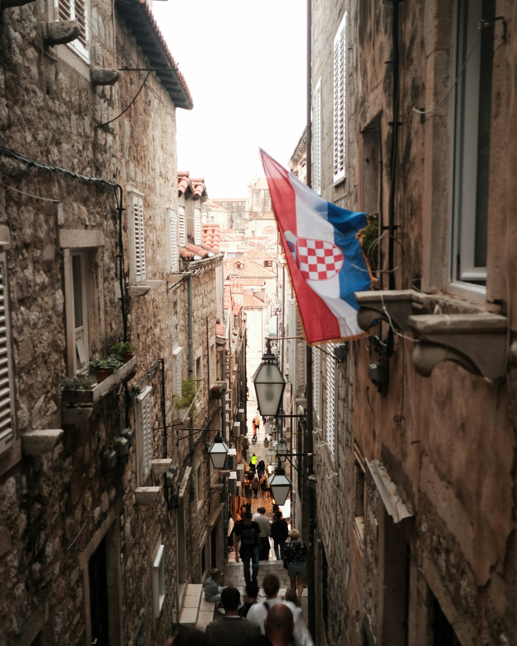The Croatian flag hanging in a narrow stone lane in Dubrovnik