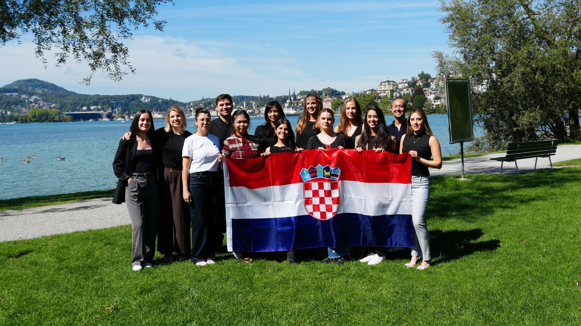 The Salona Consulting team holding the Croatian flag by Lake Lucerne.